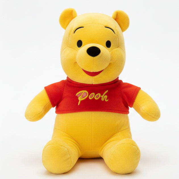 Plush toy bear in a red shirt labeled 'Pooh' on a marble surface with books in the background.