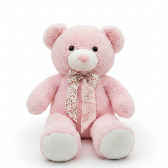Pink teddy bear with a bow tie on a shelf in a store