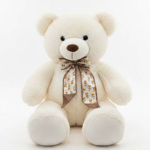 White teddy bear with a bow on a shelf in a store setting