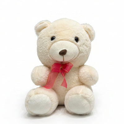 Small white teddy bear with a pink bow attached to a curtain.