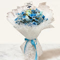 Bouquet of blue flowers wrapped in white paper with a 'Happy Father's Day' card on a white background