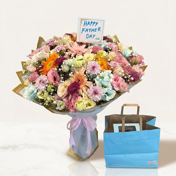 Bouquet of flowers with a 'Happy Father's Day' card and a blue gift bag on a white background