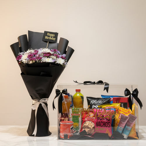 Bouquet of flowers and a gift basket with snacks on a table in a store setting.