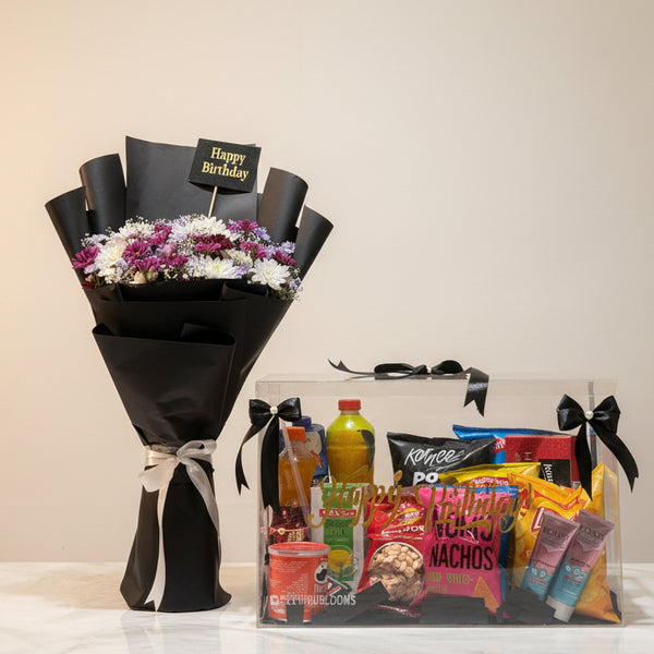 Bouquet of flowers and a gift basket with snacks on a table in a store setting.