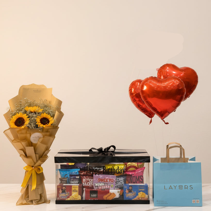 Display of flowers, balloons, and a gift bag in a store setting.