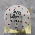 Card with 'Happy Father's Day' text and red hearts on a marble surface