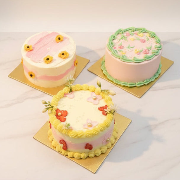 Three decorated cakes on a marble surface