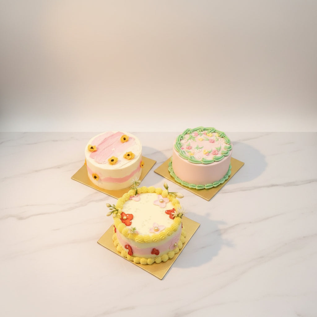 Three decorated cakes on a marble surface
